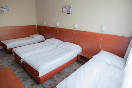 a room with two beds and two tables at Hotel Włókniarz in Pabianice