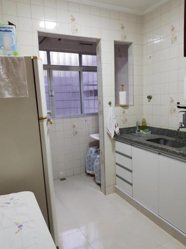 a kitchen with a sink and a refrigerator at Apartamento 2 qtos Praia de Santos in Santos
