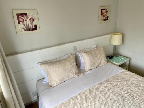 a bed with white sheets and pillows in a bedroom at UNU ITAIM BIBI in Sao Paulo