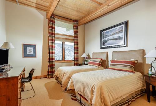 a bedroom with two beds and a desk and a television at Deluxe Two Bedroom - Aspen Alps #707 in Aspen