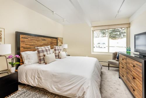 1 dormitorio con 1 cama grande y TV en Standard 2 Bedroom - Aspen Alps #206, en Aspen