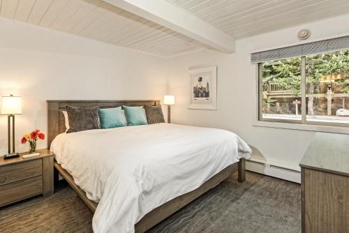 a white bedroom with a large bed and a window at Aspen Alps in Aspen