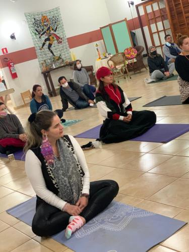 a group of people sitting on the floor in a yoga class at Gaia Hospedagem Holística in Brotas
