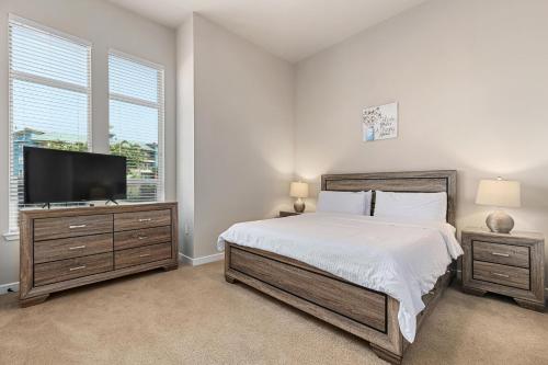 a bedroom with a bed and a flat screen tv at StayOvr at Galatyn Park in Richardson