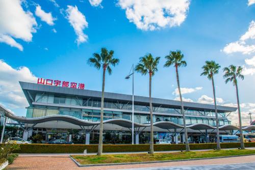 a building with palm trees in front of it at パーク琴芝 in Ube