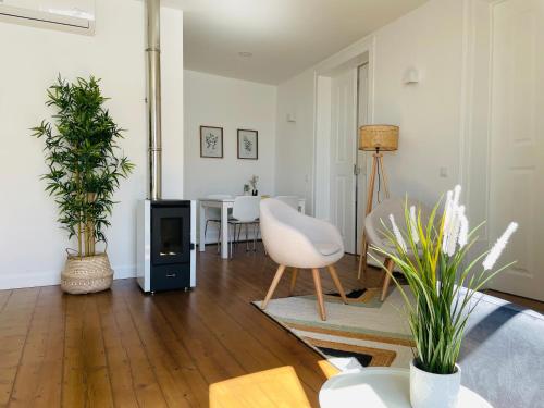 a living room with a fireplace and a white chair at Casa Soure Suites and Apartments in Évora