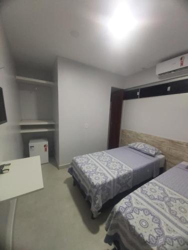 ein Hotelzimmer mit 2 Betten und einem TV in der Unterkunft Hotel Cabana in Parauapebas