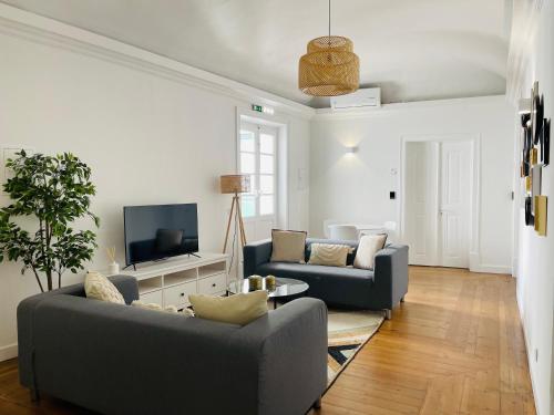 Casa Soure Suites and Apartments في ايفورا: غرفة معيشة مع كنبتين وتلفزيون