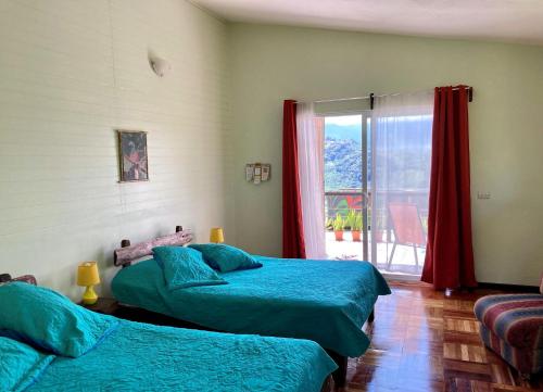 a bedroom with two beds and a window with a view at Rinconcito Verde in Ujarrás
