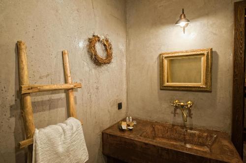 a bathroom with a wooden tub and a mirror at Montanema Handmade Village in Platanákos