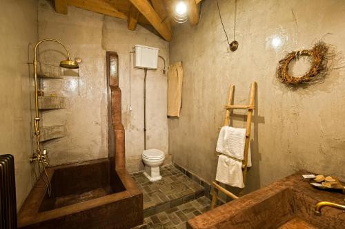 a bathroom with a tub and a toilet at Montanema Handmade Village in Platanákos