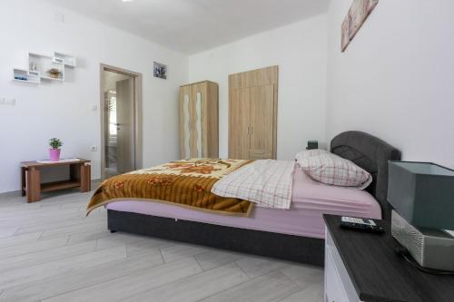 a bedroom with a bed and a flat screen tv at Apartment STUDIO in Novi Vinodolski