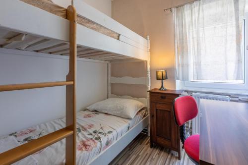 a bedroom with two bunk beds and a red chair at House RUZICA in Novi Vinodolski