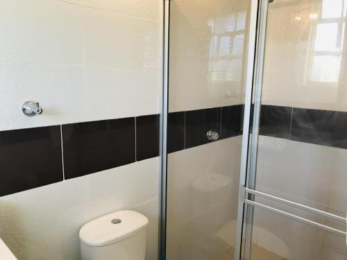 a bathroom with a toilet and a glass shower at La Luna by JR in Mariquita