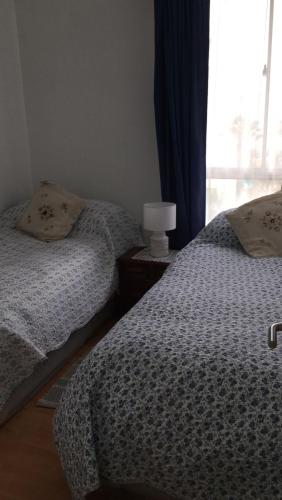 a bedroom with two twin beds and a window at Departamento por día ARICA in Arica