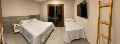 a bedroom with a bed and a flat screen tv at Pousada Maresia in Fernando de Noronha