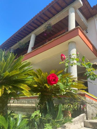 a house with red roses in front of it at Granja del Cafe Hotel y Centro de convenciones in Venecia