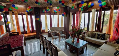 a living room with tables and chairs and balloons on the ceiling at Casa Arhan 2-3-4-7-12 BHK Luxury Penthouse in Mussoorie