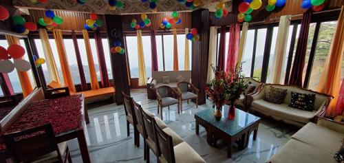 a living room with a table and chairs and balloons at Casa Arhan 2-3-4-7-12 BHK Luxury Penthouse in Mussoorie