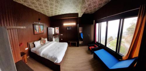 a bedroom with a bed and a large window at Casa Arhan 2-3-4-7-12 BHK Luxury Penthouse in Mussoorie