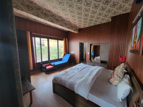 a bedroom with a large bed and a blue chair at Casa Arhan 2-3-4-7-12 BHK Luxury Penthouse in Mussoorie