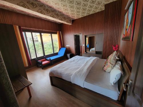 a bedroom with a bed and a chair in a room at Casa Arhan 2-3-4-7-12 BHK Luxury Penthouse in Mussoorie