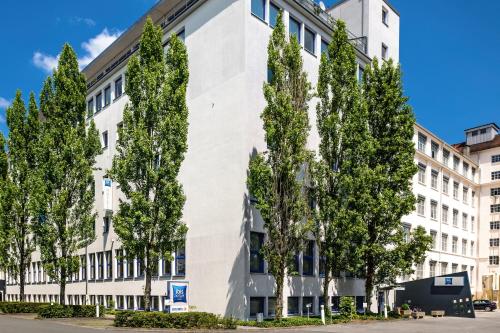 a white building with trees in front of it at ibis budget Nürnberg City Messe in Nürnberg