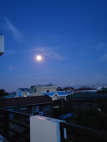 a moon in the sky over a city at night at ANDY'S PLACE in Legazpi