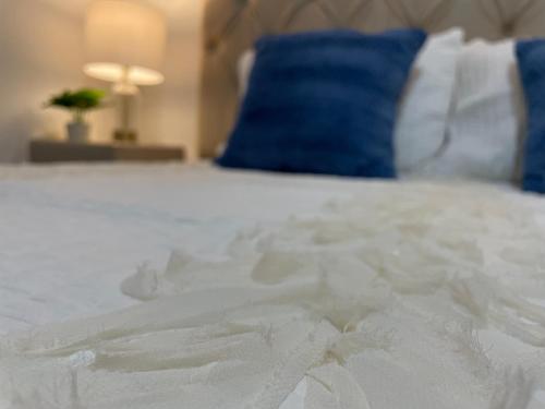 a close up of a white bed with a blue pillow at Fino y Elegante Condominio Ejecutivo in San Pedro Sula