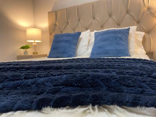 a bed with a blue blanket and pillows at Fino y Elegante Condominio Ejecutivo in San Pedro Sula