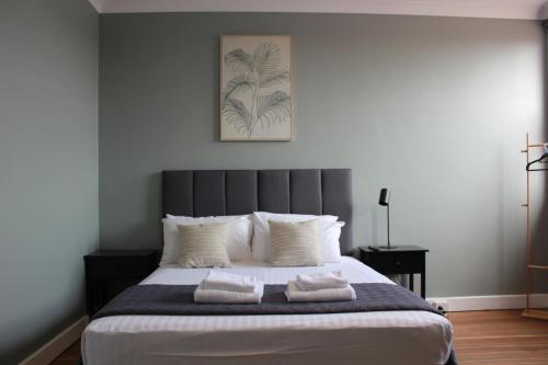 a bedroom with a large bed with two towels on it at Colliery Inn Wallsend in Newcastle