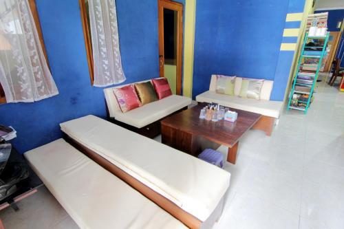 um quarto com dois bancos e uma mesa e cadeiras em Griya Ardafa em Yogyakarta