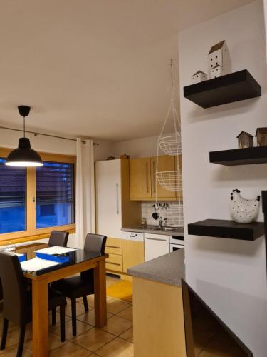 森特的住宿－Ferienwohnung Scandella Otto und Monika，厨房以及带桌椅的用餐室。
