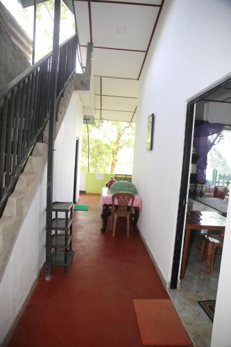 un pasillo con mesa y sillas en un edificio en 9 Arch view rest inn, en Ella