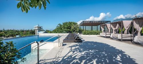 a swimming pool with chairs next to a swimming pool at Lakeshore Hotel Hualien Taroko in Shunan