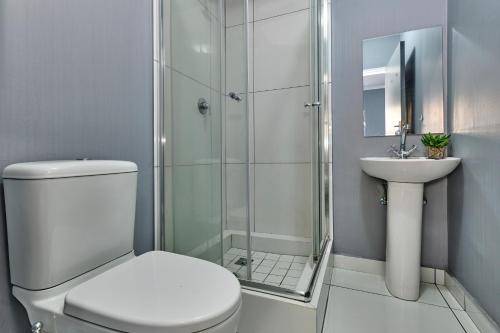 Un baño con ducha, inodoro y lavabo. en Inn & Out Sandton, en Johannesburgo