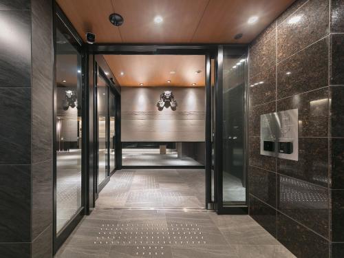 a hallway with glass doors in a building at CHISUN STANDARD Kyoto Horikawa Gojo in Kyoto