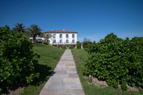 a white house with a pathway in front of it at Hôtel La Réserve in Saint-Jean-de-Luz