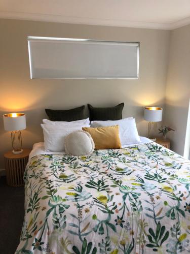 1 dormitorio con 1 cama grande con colcha de flores en Harbour Lookout, en Strahan