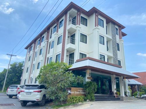 a building with cars parked in front of it at Narai Iyara Palace in Ban Sa Maklua