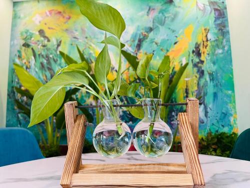 two glass vases sitting on top of a table at The Tray Hotel Hai Phong in Hai Phong