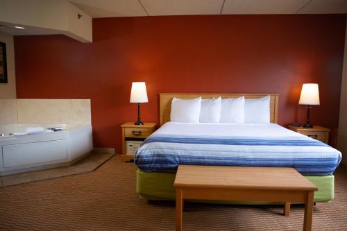 a hotel room with a bed and a bath tub at AmericInn by Wyndham Pampa Event Center in Pampa