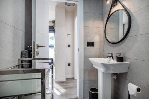 een badkamer met een wastafel en een spiegel bij Luxurys Costasol33 Aptos 1 y 2 in Córdoba