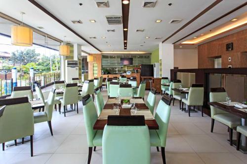 a dining room with tables and chairs in a restaurant at Alpa City Suites Hotel in Cebu City