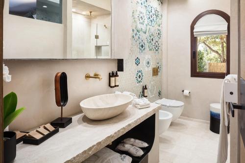a bathroom with a sink and a toilet at Hotel delle Rose a Luxury Boutique Hotel in Porto Cervo