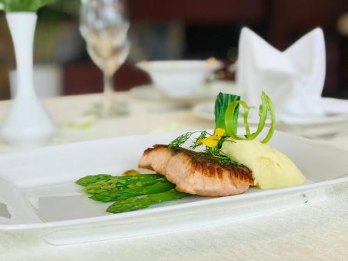 a white plate with a piece of food on a table at The Tray Hotel Hai Phong in Hai Phong