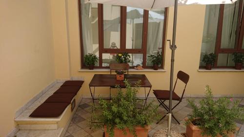 patio ze stołem, krzesłami i oknami w obiekcie Loft La Corte w mieście Pietrasanta