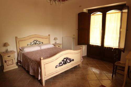 a bedroom with a bed and two tables and a window at Villa Manca in San Severino Lucano