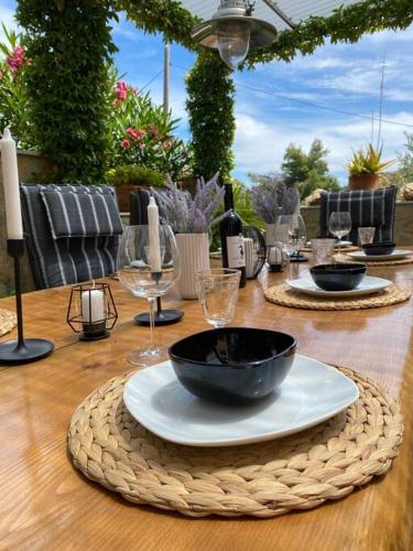 a wooden table with a black bowl and wine glasses at Villa Mala - Pool - Jacuzzi - 5 min. zum Meer in Trogir