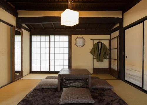 una camera con tavolo in una stanza con finestre di もしもしの家 a Koshu